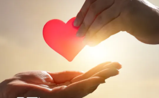 Graphic image of one hand giving a paper heart to another hand to represent giving