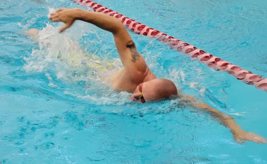 Close up of man swimming laps lane in pool