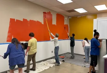 Teens and Y staff painting the walls of the new teen resource room