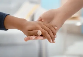 Image of a holding hands of a child and an adult.